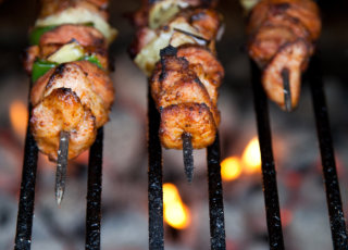 Juicy kebabs cooking over hot charcoal, showcasing the grilling process by FoodByWayne