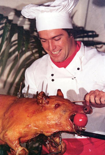 Chef carving a whole spit roasted pig by FoodByWayne